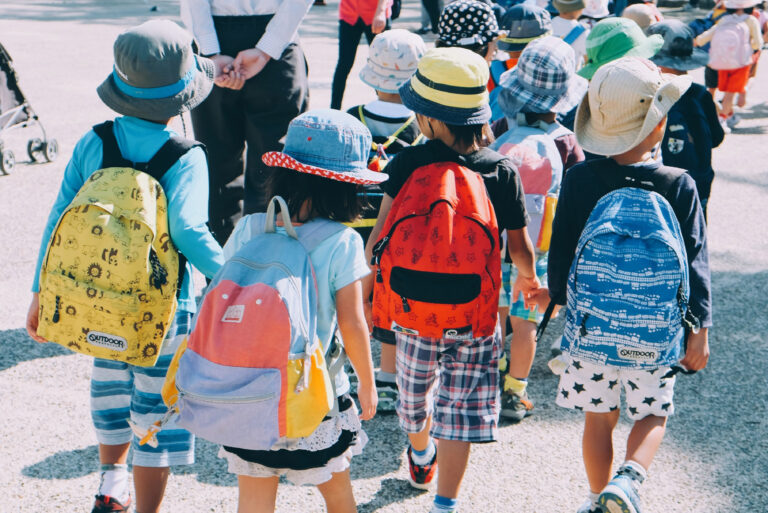 attività per bambini e ragazzi durante l'estate: gruppo di bambini in gita ripresi di spalle